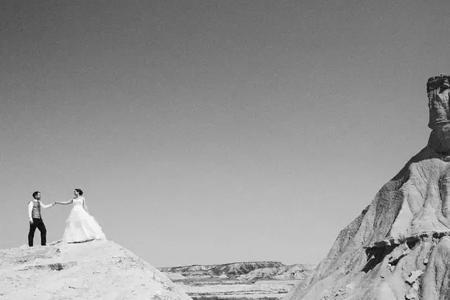 Novios dándose la mano en las Bardenas Reales, fotografía de boda en blanco y negro de Josu Izarra
