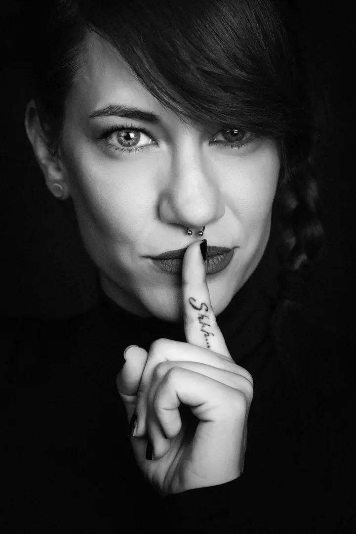 Retrato en blanco y negro de una mujer con el dedo sobre los labios, premio Lux, por Josu Izarra